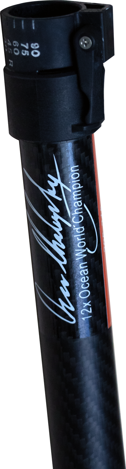 Close-up of a black carbon-fiber paddle shaft with a black plastic clamp at the top, featuring white script text reading Oscar Chalupsky' and '12X Ocean World Champion' printed along the shaft.