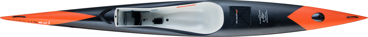 Top-down view of a sleek, modern ChalupSKI Tarifa Carbon surfski in black and orange, featuring a white interior cockpit and visible cockpit hardware.